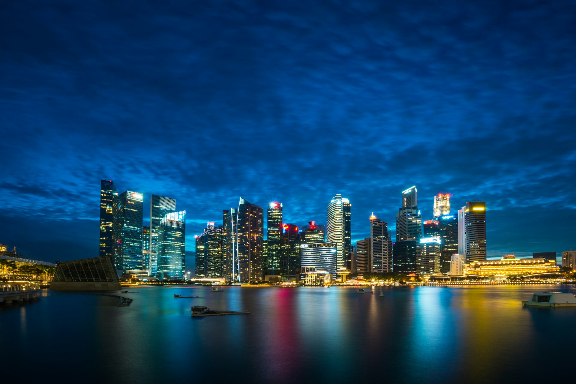 city buildings beside body of water under cloudy sky